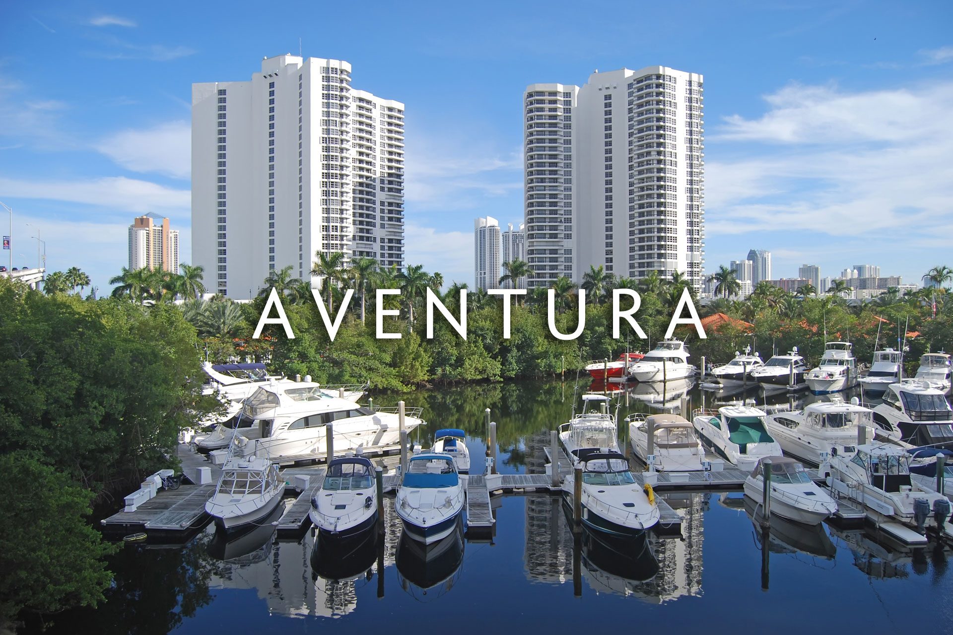 Aventura condo buildings on oceanway with various yachts in front of them